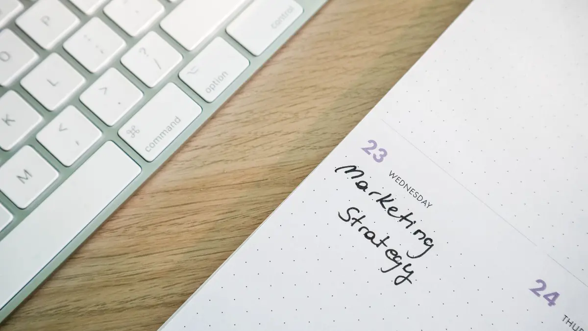 Close-up of a desk with a keyboard and a calendar open to a marketing strategy note, illustrating clinic marketing ideas