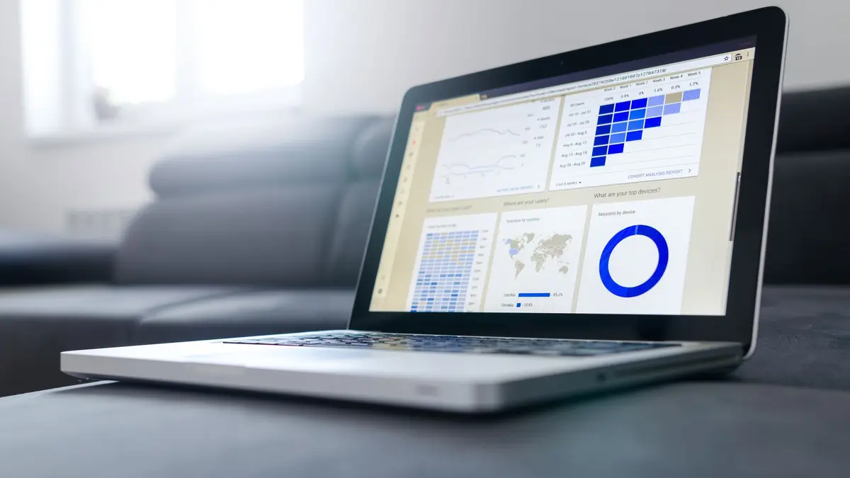 Sleek laptop showcasing data analytics and graphs on the screen in a bright room, illustrating digital marketing for aesthetic clinics