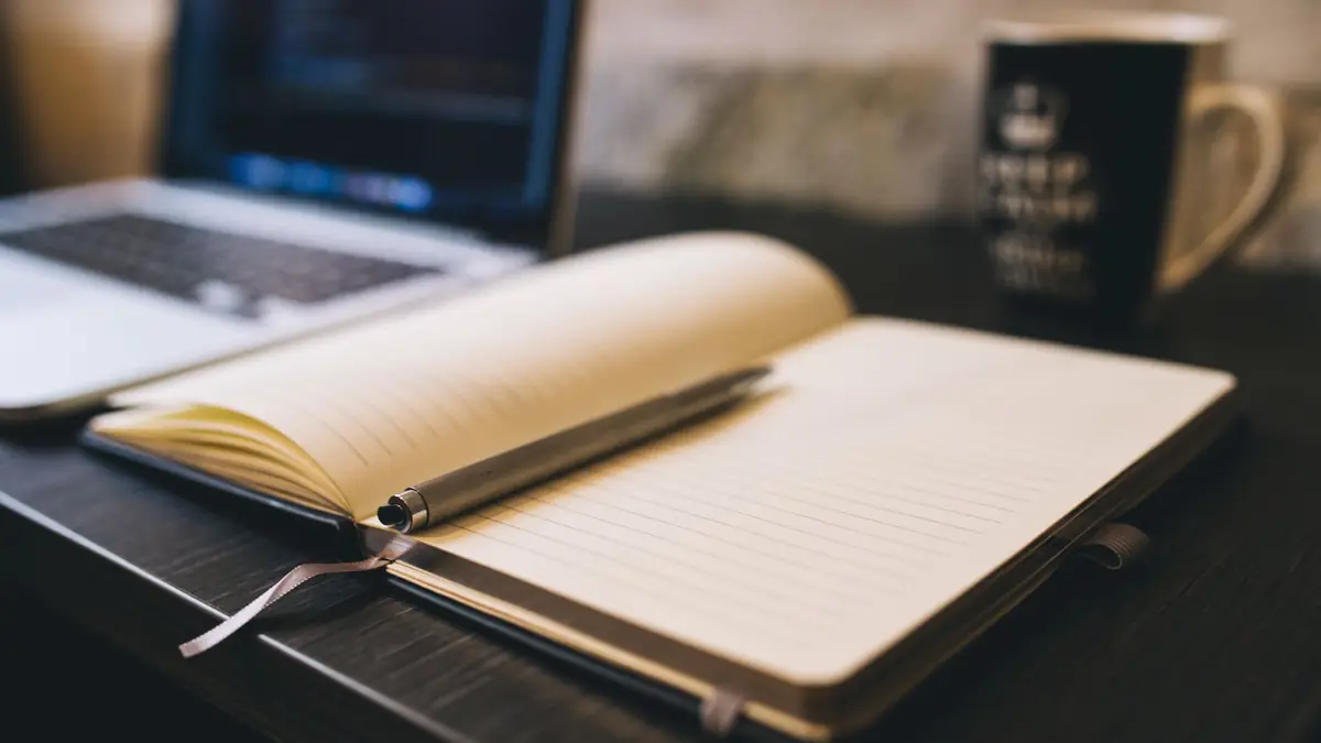 Open notebook with a pen on a wooden desk beside a laptop, illustrating med spa marketing ideas